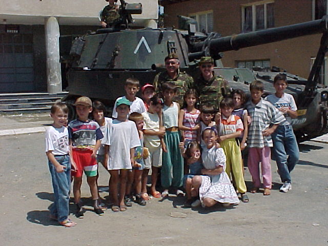 Hans en Q in Orahovac Met M109 Gedle RIjders en kinderen
